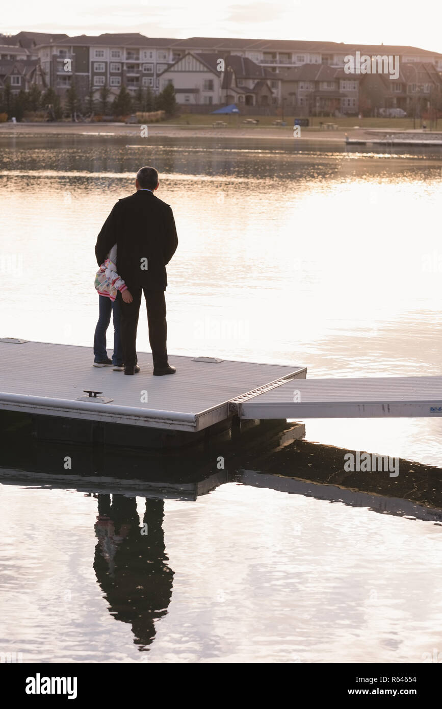 Nonno e nipote in piedi sul molo vicino a lato lago Foto Stock