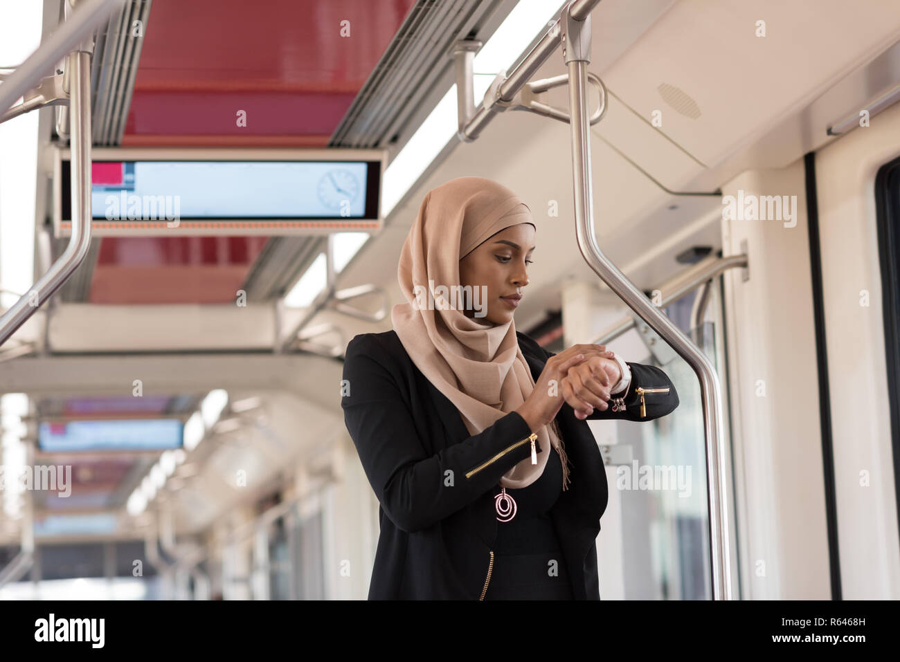 Donna che utilizza smart guardare durante il viaggio in treno Foto Stock