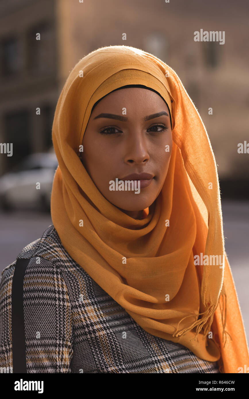 Il hijab donna che guarda la telecamera in città Foto Stock
