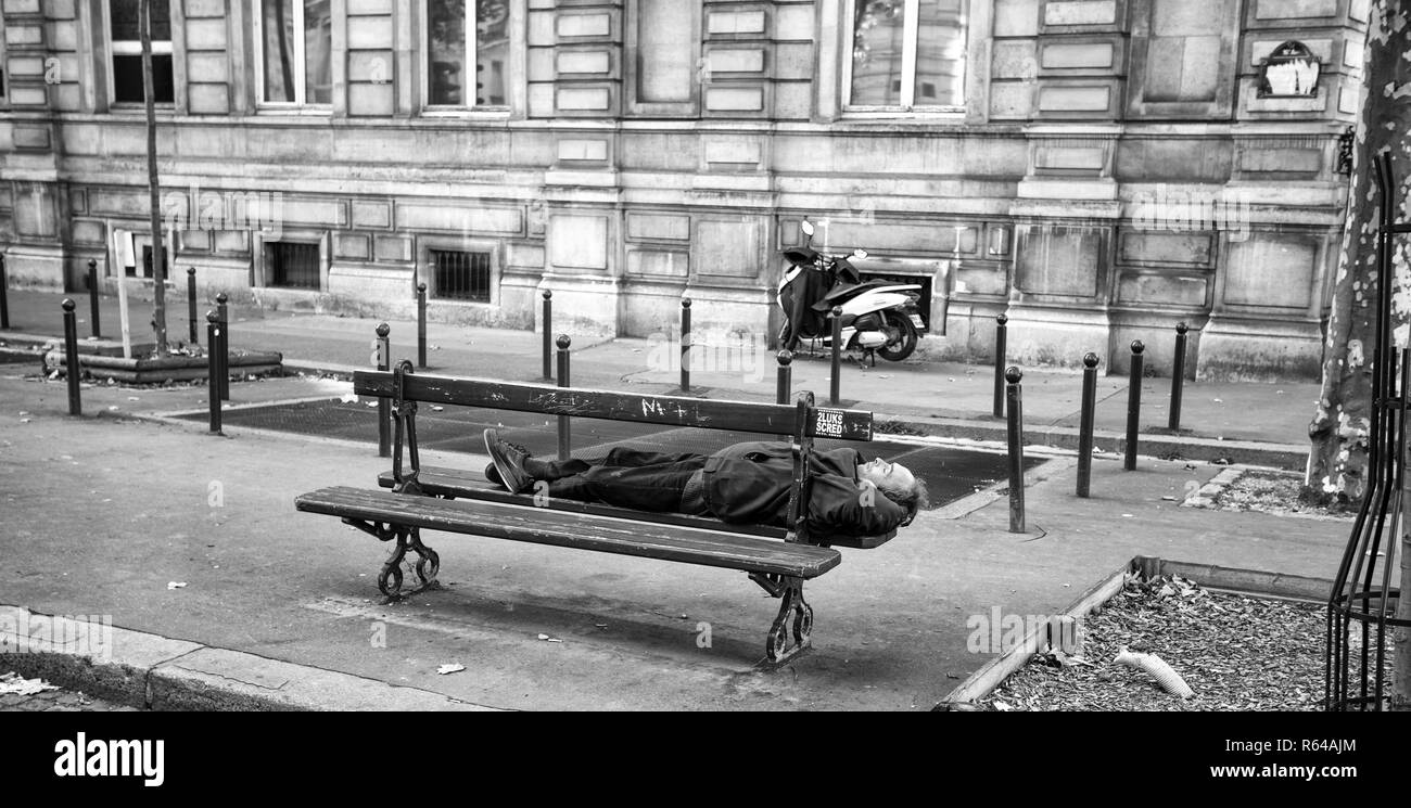 Parigi, Francia, 7 settembre 2018 - un uomo di dormire su una panca di legno per le strade di Parigi, Francia. Foto Stock