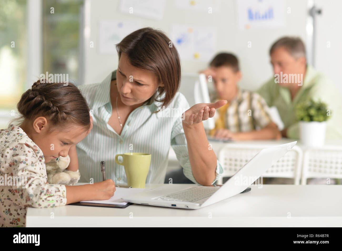 Giovane madre aiutando il suo incantevole piccola figlia Foto Stock