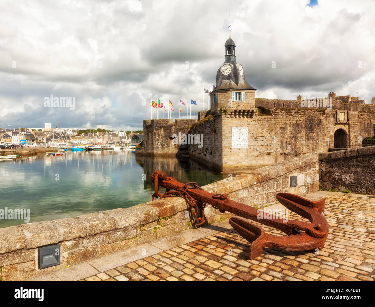 Della città murata di Concarneau con torre dell'orologio. Ancoraggio arrugginito in foregrond, marina in background Foto Stock