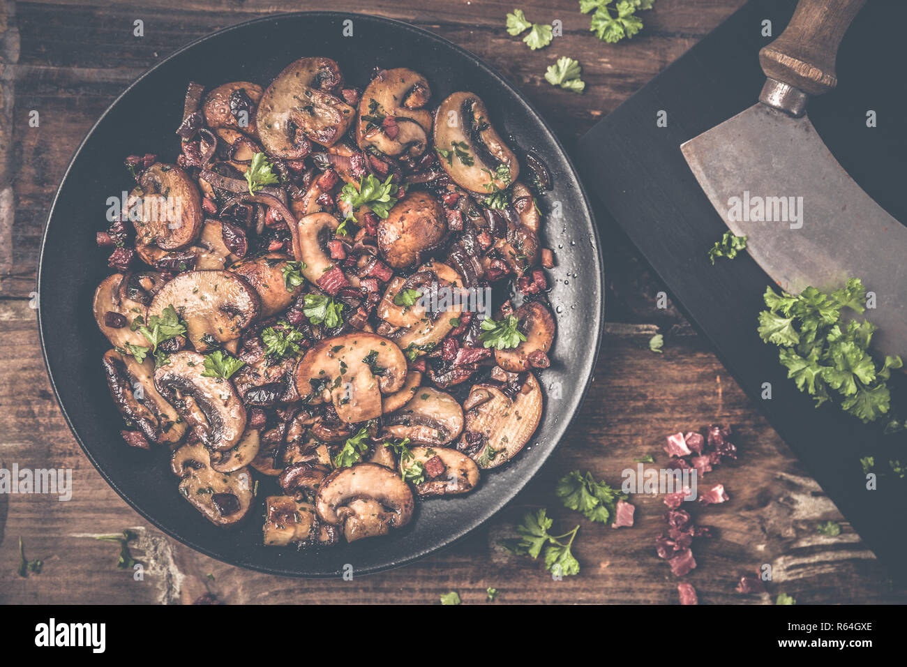 Funghi con prosciutto e le cipolle raffinato con prezzemolo Foto Stock