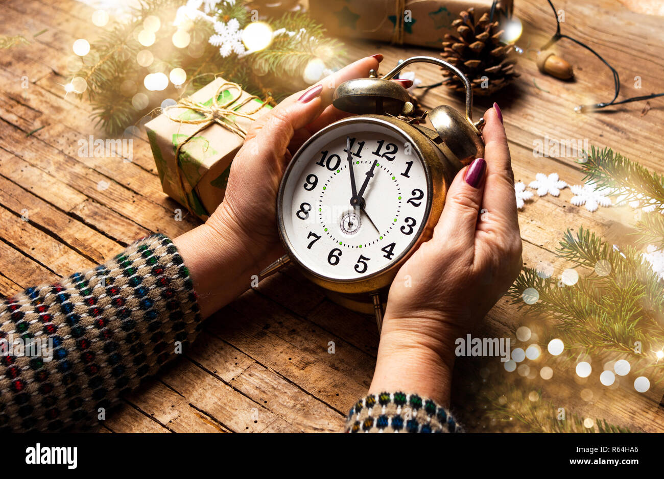 Donna che mantiene un orologio vintage in ambiente festoso pov Foto Stock