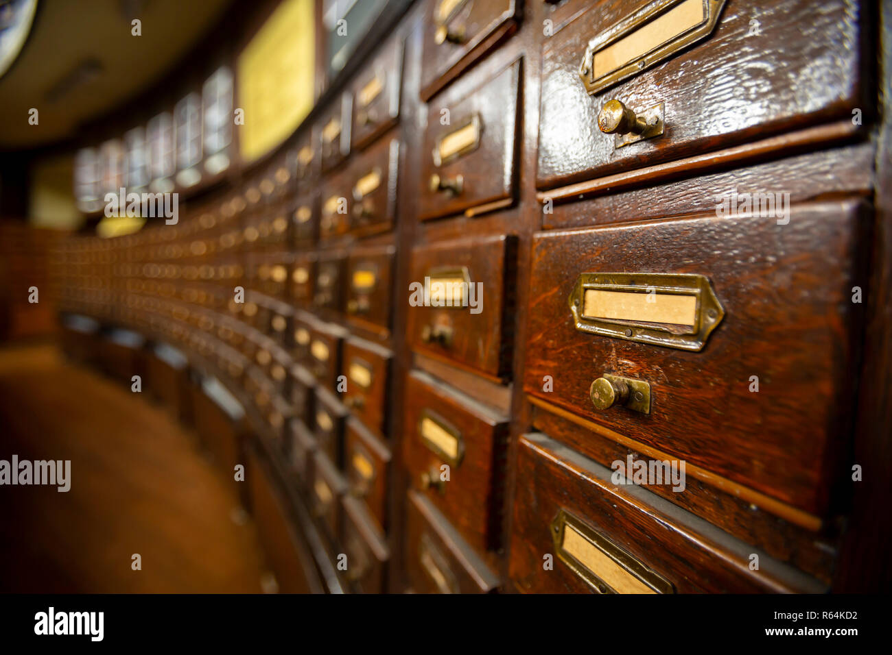 I cassetti in legno con ornamenti di metallo in una vecchia libreria. Scatole di legno con le schede indice nella libreria. Foto Stock