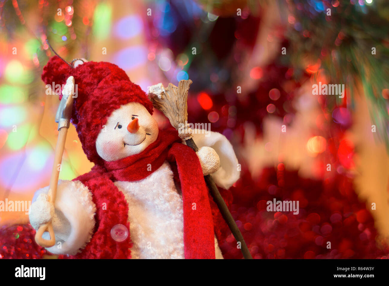 Felice pupazzo di neve sotto l albero di Natale contro sfondo bokeh di fondo. Buon anno nuovo spirito. Anno nuovo concetto di Natale Foto Stock