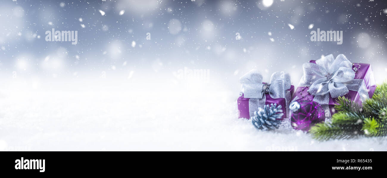 Il Natale di lusso doni viola nella neve e astratto atmosfera nevoso. Foto Stock