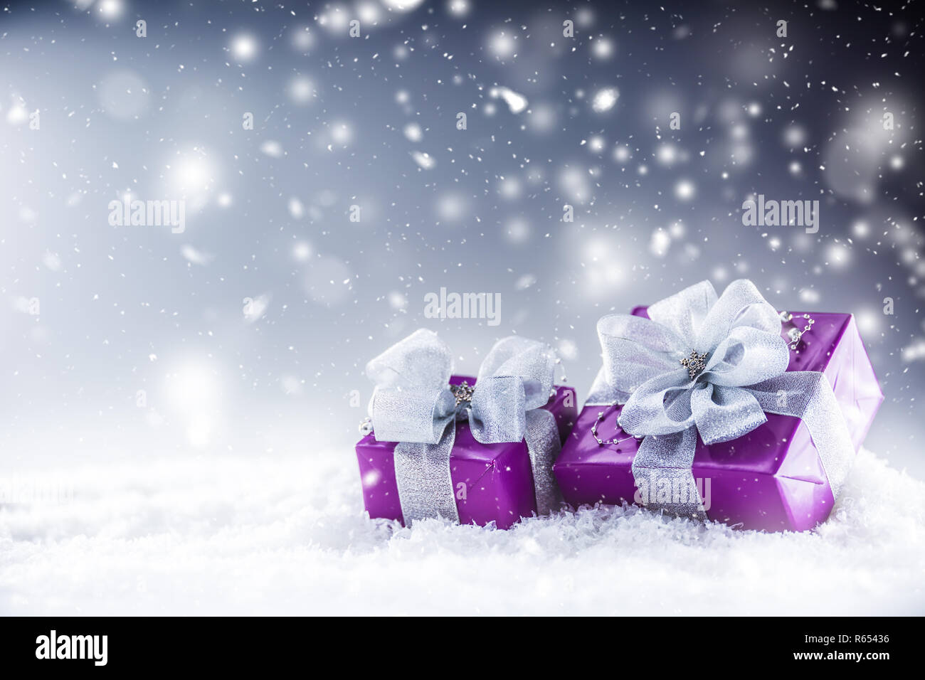 Il Natale di lusso doni viola nella neve e astratto atmosfera nevoso. Foto Stock