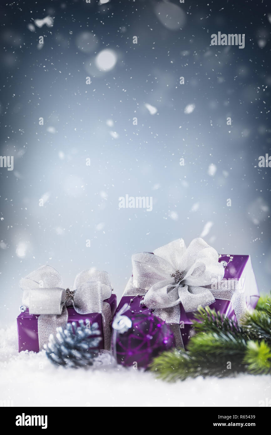 Il Natale di lusso doni viola nella neve e astratto atmosfera nevoso. Foto Stock