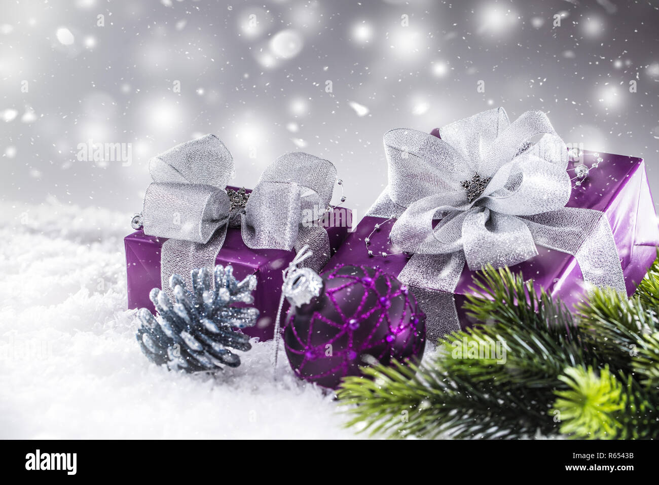 Il Natale di lusso doni viola nella neve e astratto atmosfera nevoso. Foto Stock