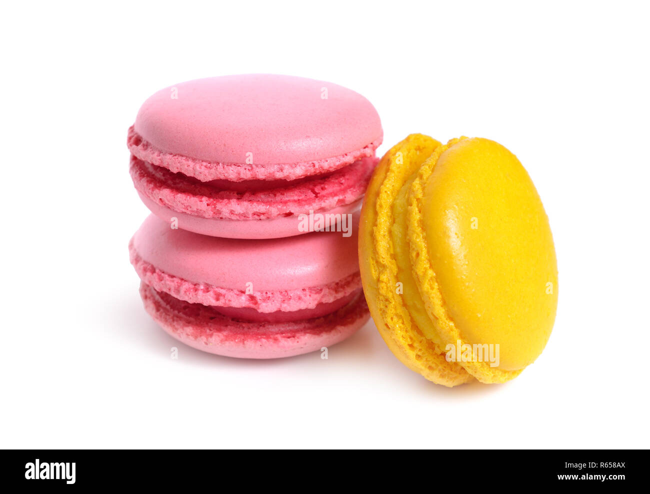 Un macaron o amaretto francese. Piccolo presente con giallo e rosa. Isolato. Foto Stock