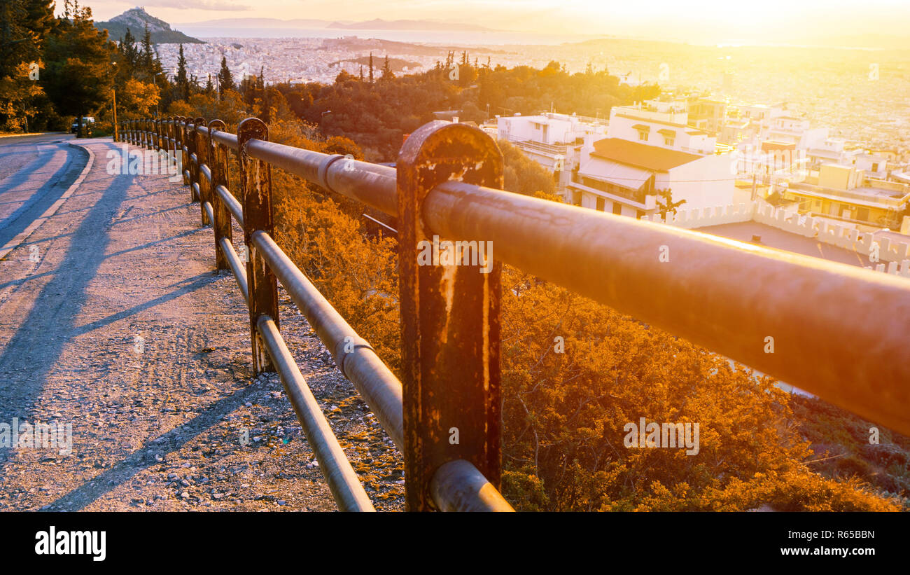 Vista del paesaggio di Atene. Su strada e crash barriera sul primo piano. Tramonto e autunno Foto Stock