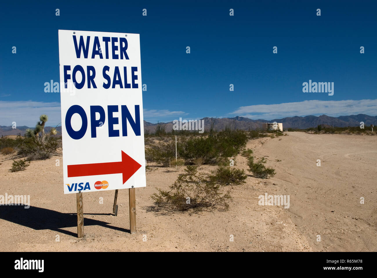 La freccia rossa che indica "acqua in vendita" nel deserto dell'Arizona, USA, simboleggia sete, scarsità e sopravvivenza. Foto Stock