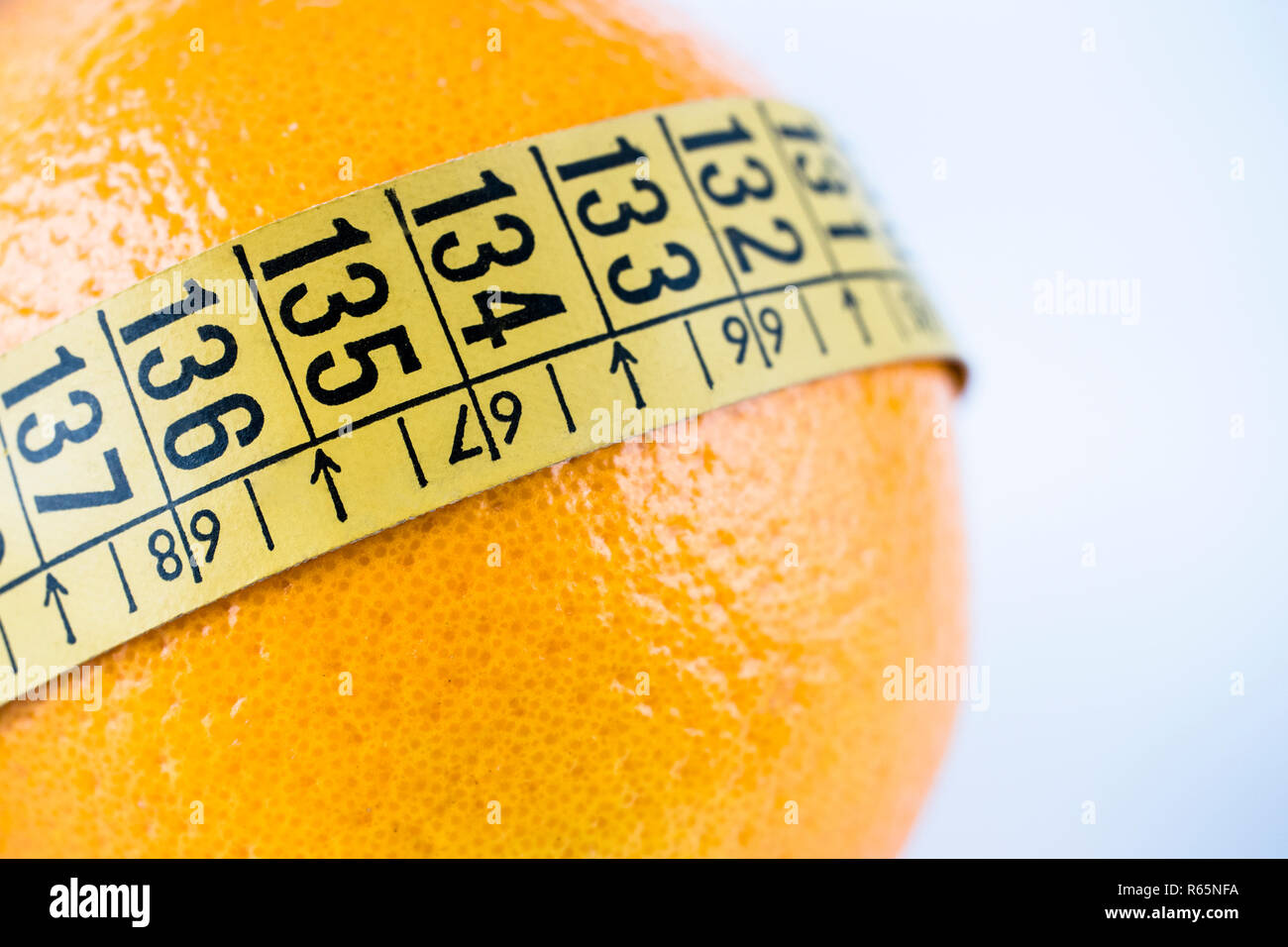 Nastro di misurazione su orange, isolato su sfondo bianco, immagine concettuale Foto Stock