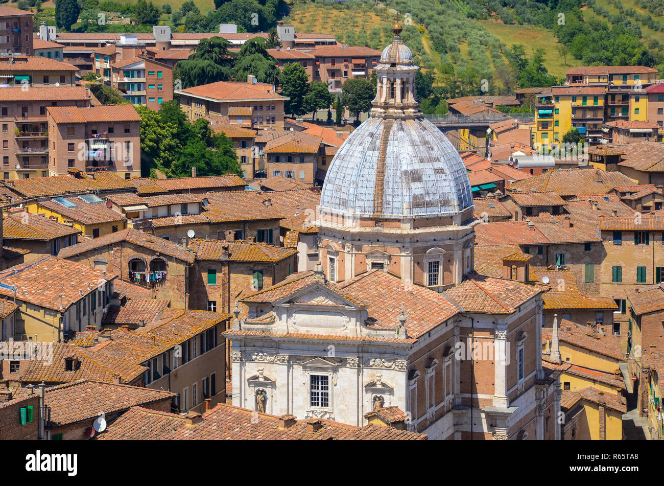 Vista sui tetti di edifici colorati a Siena, Italia che circonda la cupola blu di stile Renaissance-Baroque chiesa di Santa Maria in Provenzano Foto Stock