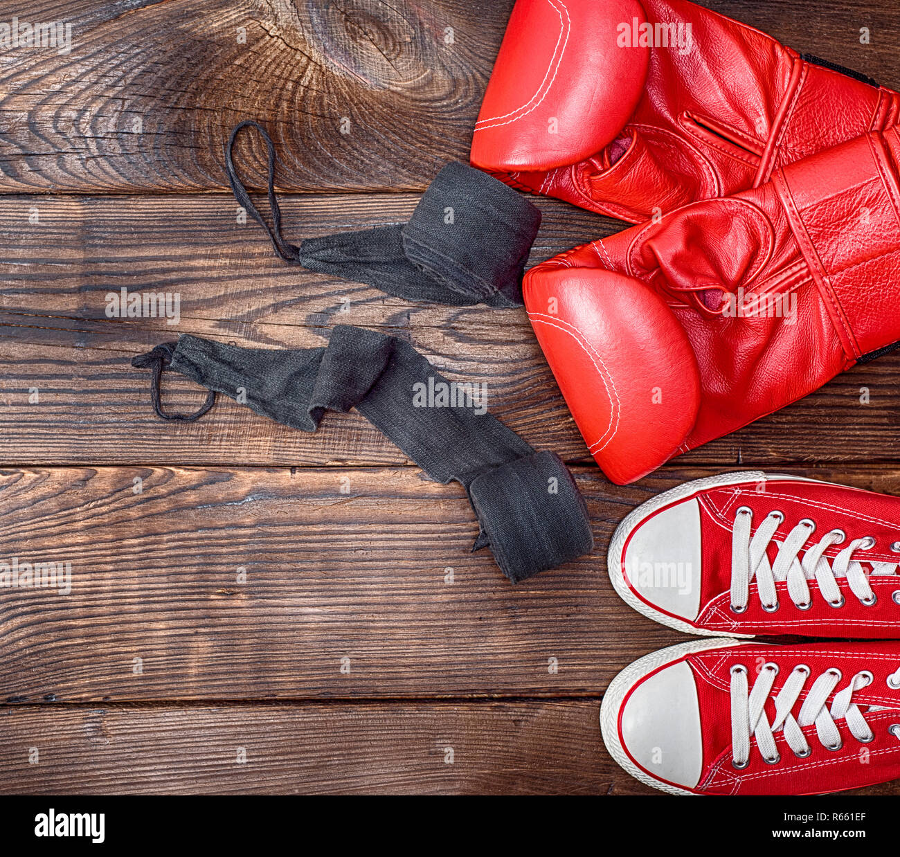 Coppia di rosso sneakers tessili e di cuoio rosso guantoni da pugilato Foto Stock