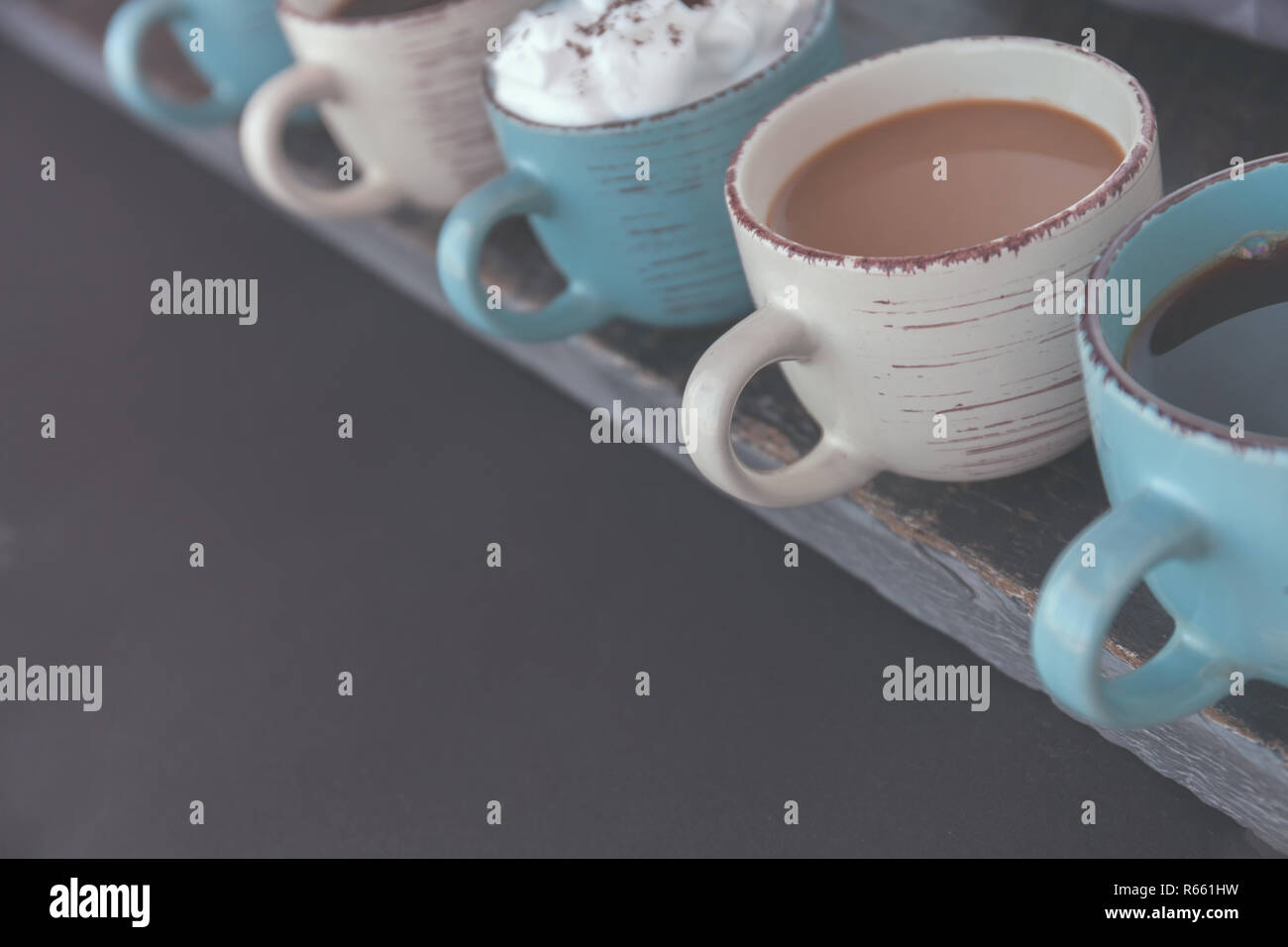 Fila di tazze da caffè con caffè fresco su un tavolo di legno. Lo spazio negativo per il testo Foto Stock