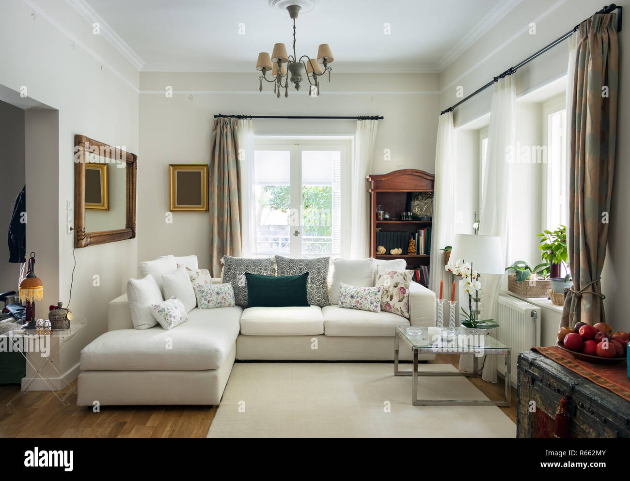 Ampio soggiorno molto ansa con pavimento di legno di quercia, quattro sedi divano, tappeto bianco e retrò objets, Grecia. Foto Stock
