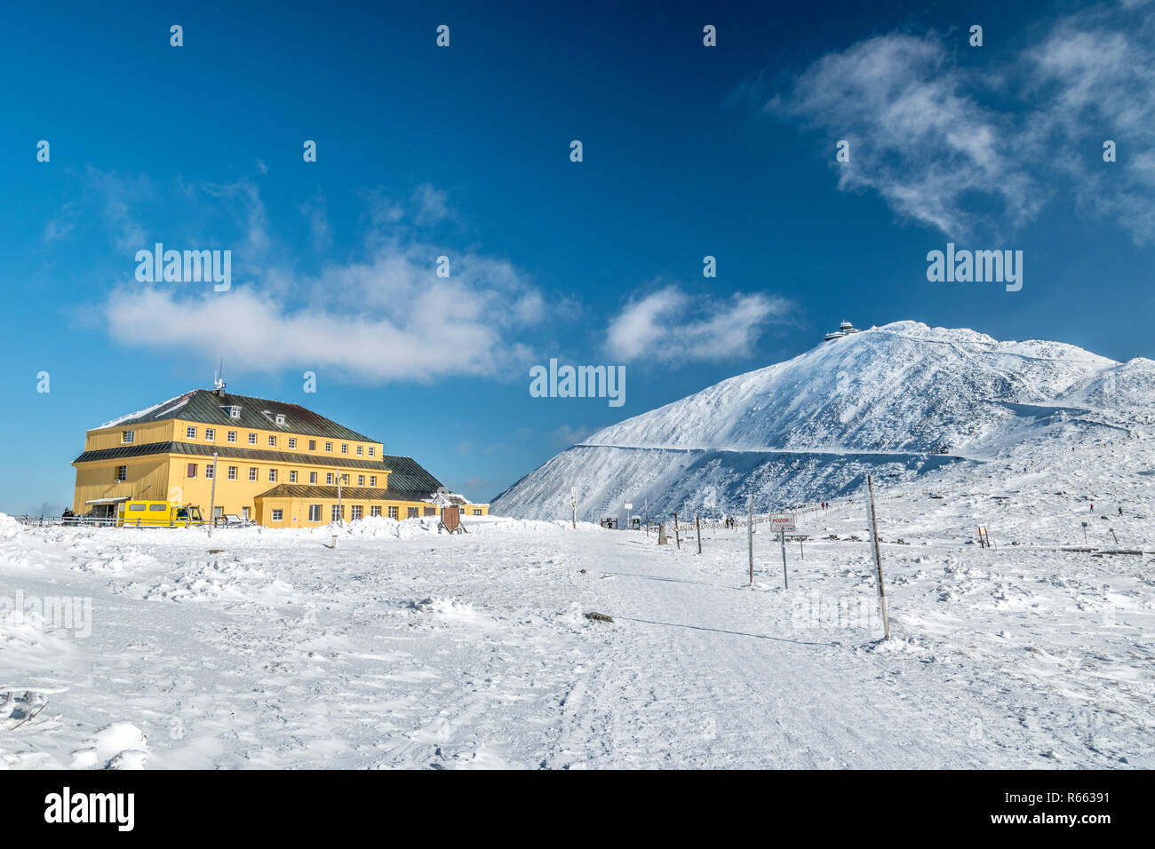 Slezsky dum (Slaski dom) baita di montagna con picco Snezka in dietro in una giornata di sole in inverno le montagne di Krkonose, Repubblica Poland-Czech confine Foto Stock