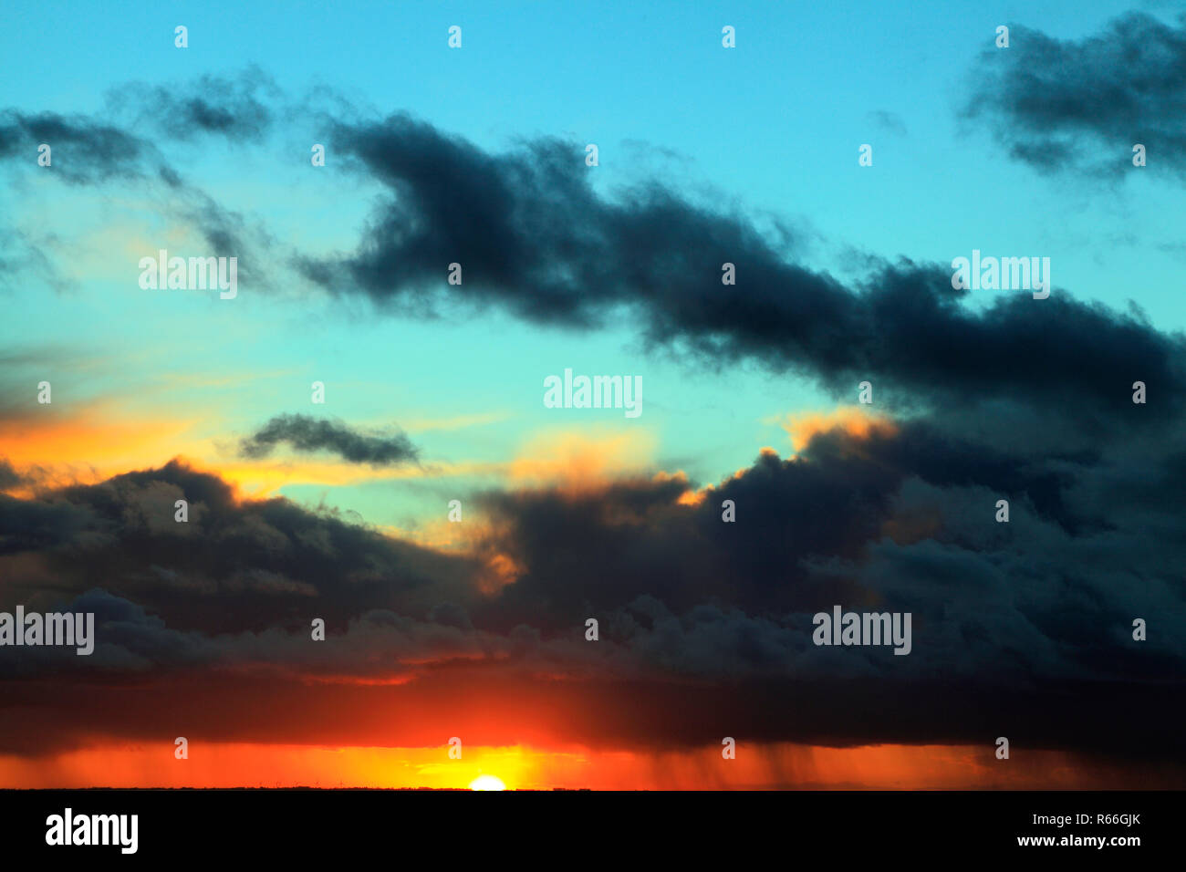 Sunset, rosso, blu, rosa, sky, nuvole nere, raccogliere tempesta, meteo, cieli, sky, formazione, formazioni, luce della sera, Norfolk, Inghilterra, Regno Unito Foto Stock