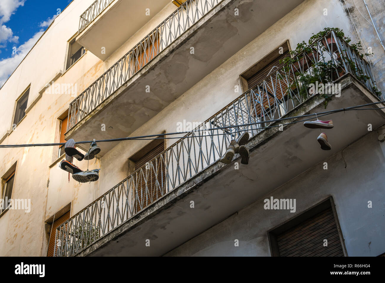 Paia di scarpe sono infilate attraverso i complessi di appartamenti nel centro urbano della città portuale di Brindisi in Italia nella regione Puglia Foto Stock
