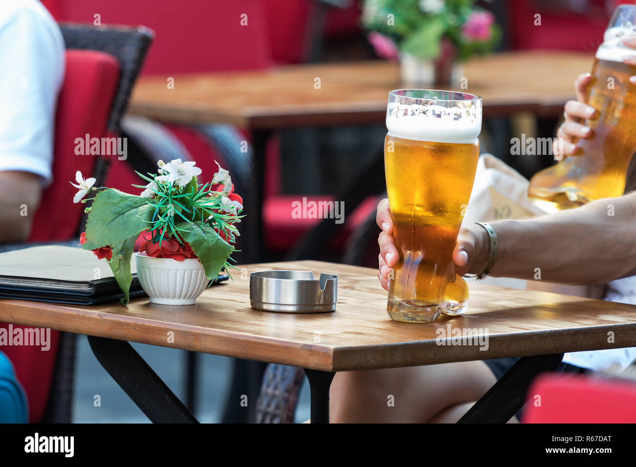Una donna mano prendere una birra su un vetro di grandi dimensioni con  forma di avvio Foto stock - Alamy