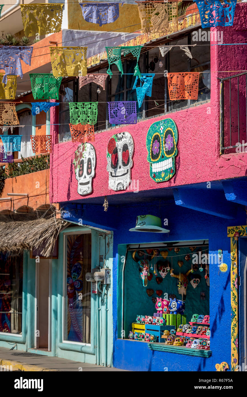 Caramelle colorate cranio arte e papel picado bandiere sulla parte anteriore del esto es Messico galleria d'arte a Sayulita, Nayarit, Messico, quartiere dello shopping. Foto Stock