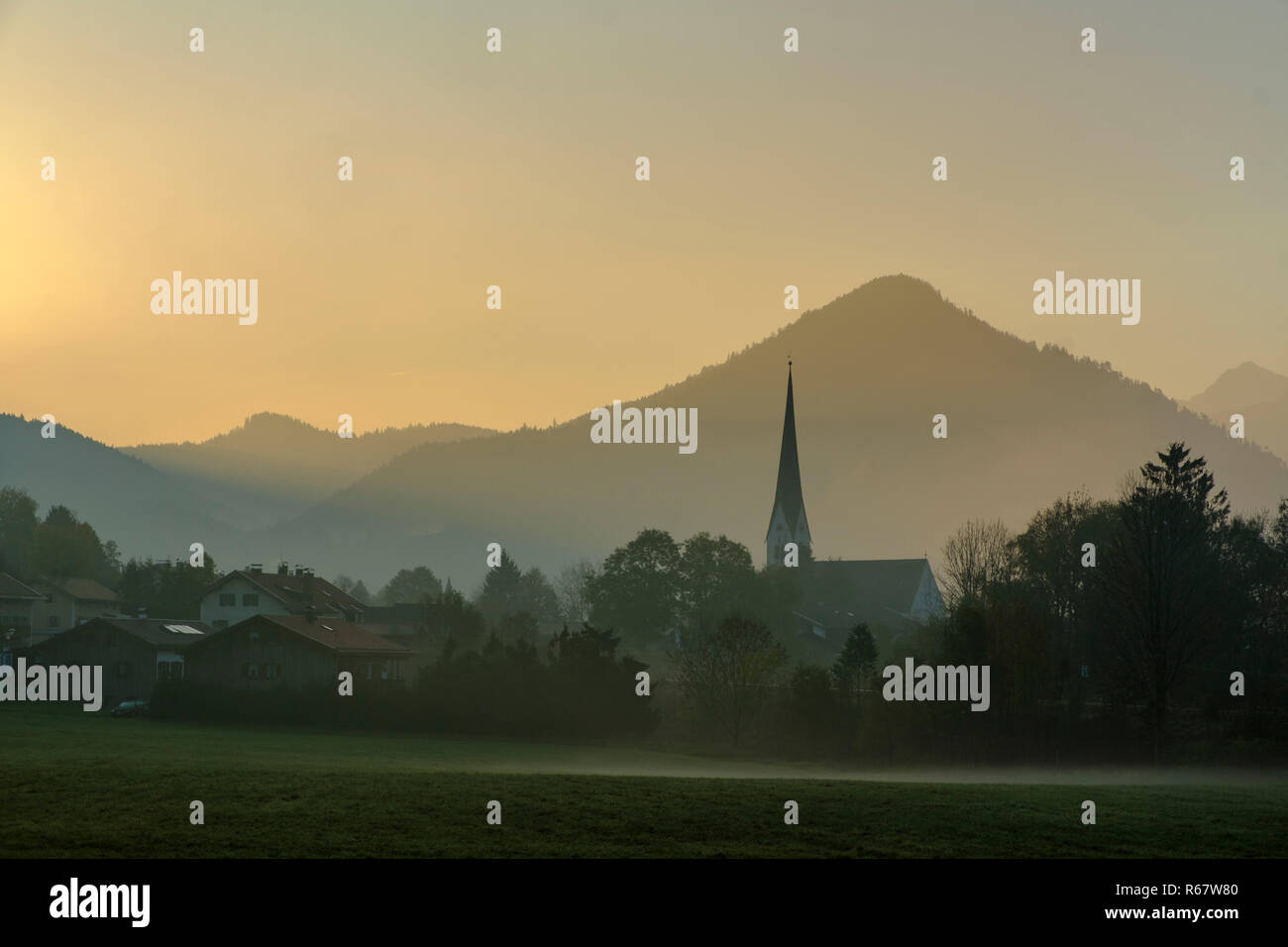 Atmosfera di mattina con la nebbia mattutina, la chiesa di San Martino a Bergen, Schliersee, Alta Baviera, Baviera, Germania Foto Stock