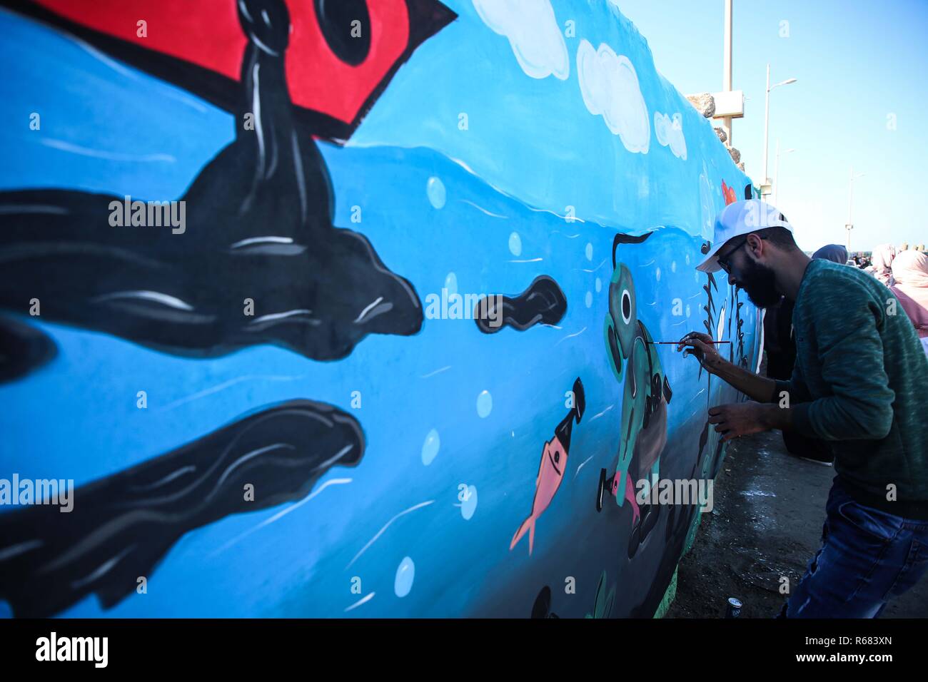 La città di Gaza, la striscia di Gaza, la Palestina. 4° dic, 2018. Artista palestinese disegnare sul muro a Gaza city porta. Credito: Hassan Jedi/Quds Net News/ZUMA filo/Alamy Live News Foto Stock