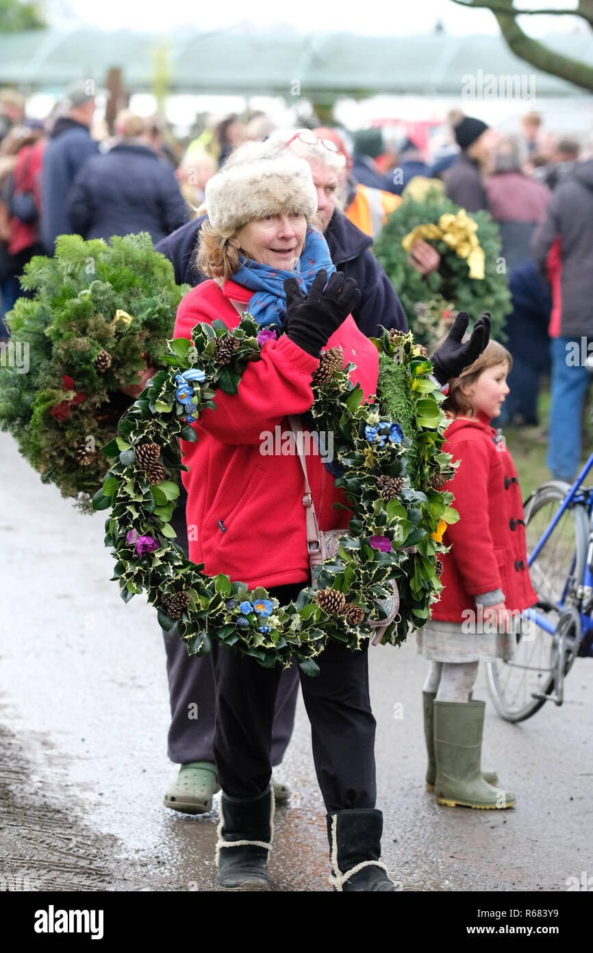 Burford House, Tenbury Wells, Worcestershire, Regno Unito - Martedì 4 dicembre 2018 - Natale agrifoglio e vischio asta - Aste di vischio si sono svolti a Tenbury Wells per oltre 160 anni. Un acquirente porta via il suo acquisto di Xmas holly ghirlande su un nitido inverno mattina. Foto Steven Maggio / Alamy Live News Foto Stock