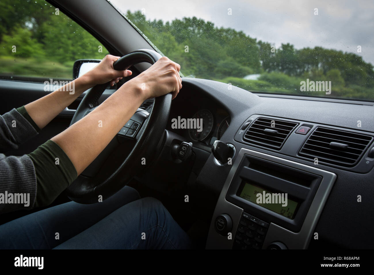Maschio di mani del conducente alla guida di una vettura su una autostrada (colore immagine dai toni shallow DOF) Foto Stock