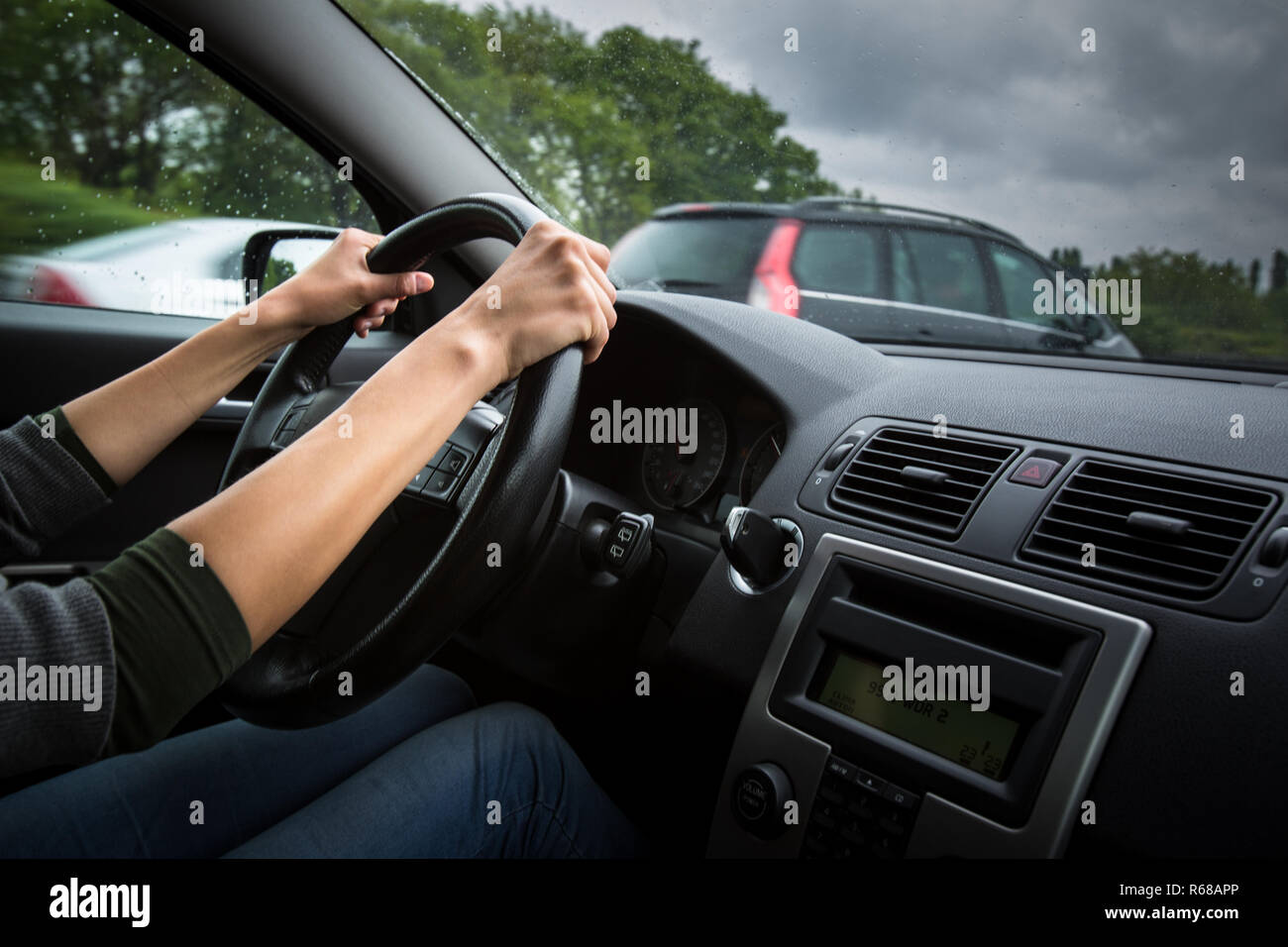 Maschio di mani del conducente alla guida di una vettura su una autostrada (colore immagine dai toni shallow DOF) Foto Stock