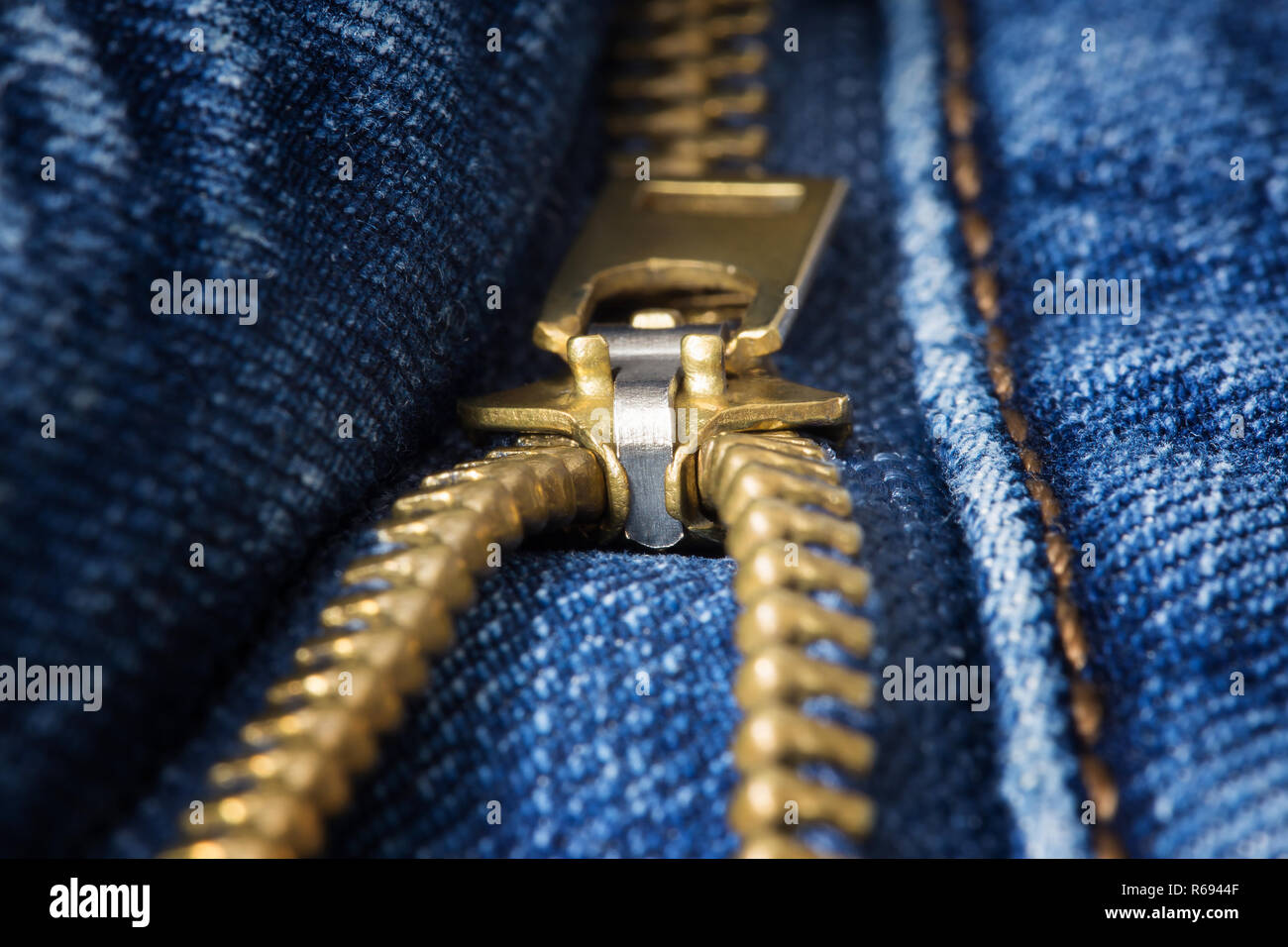 Ottone decompressi zipper closeup sul jeans blu Foto Stock