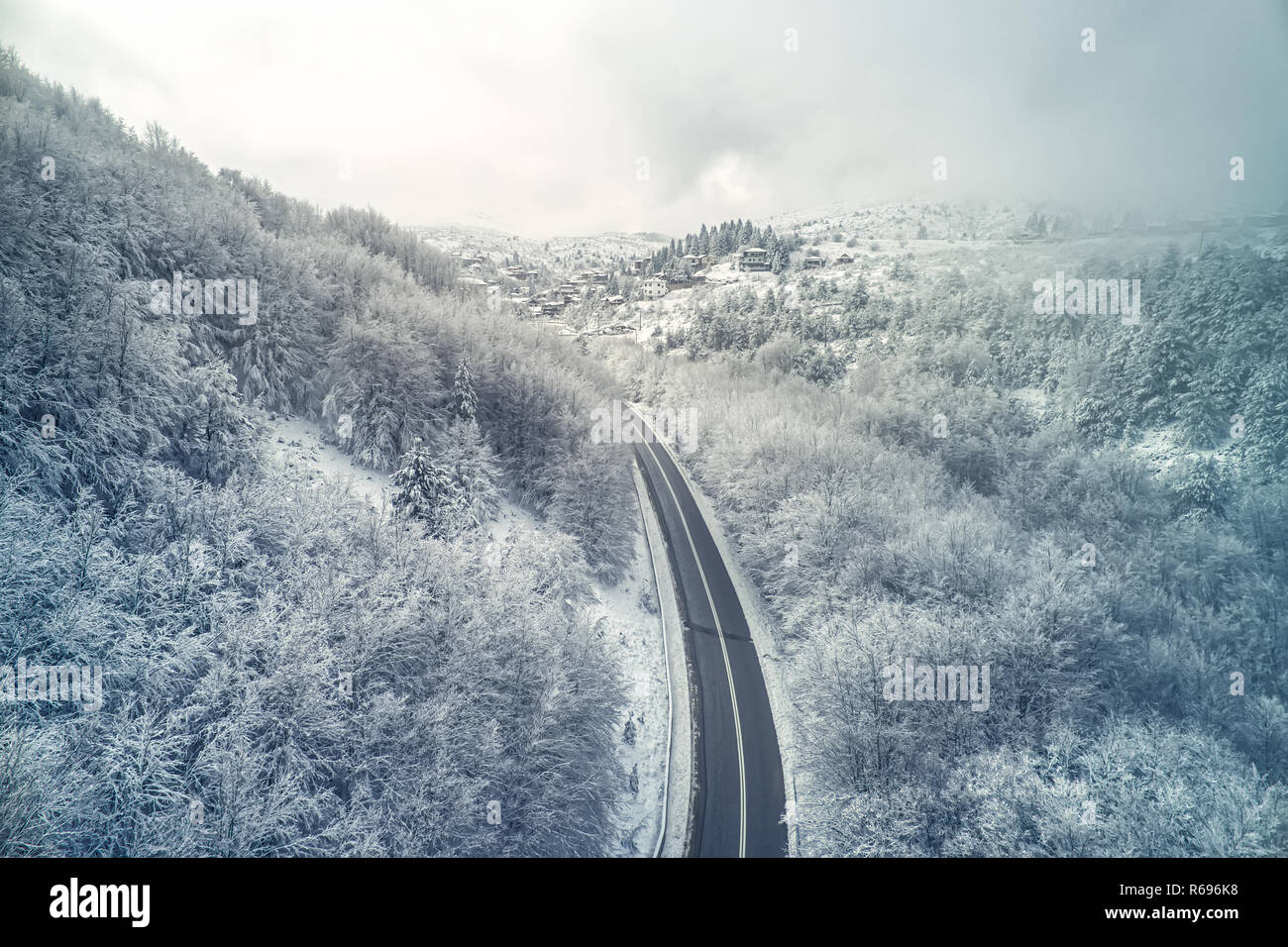 Vista aerea di Seli tradizionale villaggio Greco coperta di neve. Montagne e strada durante d'inverno. Top destinazione turistica in Grecia settentrionale Foto Stock