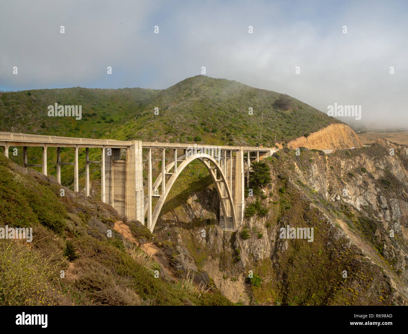 Big Sur Costa della California, bridge, spiaggia, rocce, nubi e onde di surf Foto Stock
