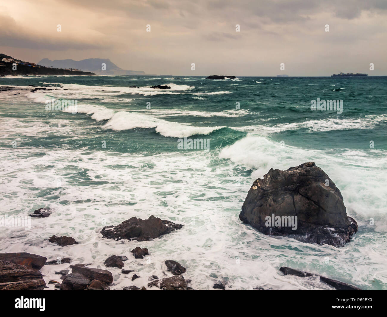 Gli spruzzi delle onde sulle coste rocciose dello Stretto di Gibilterra Foto Stock