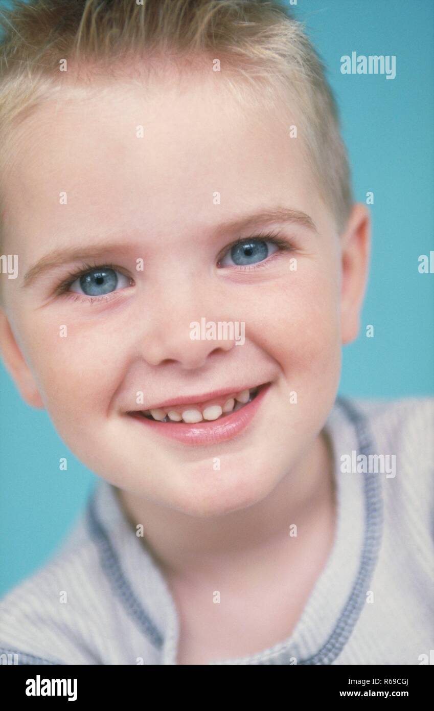 Ritratto, Nahaufnahme, blondr Junge mit grossen blauen Augen, 6 Jahre, laechelnd zeigt seine 2 neuen Zaehne Foto Stock