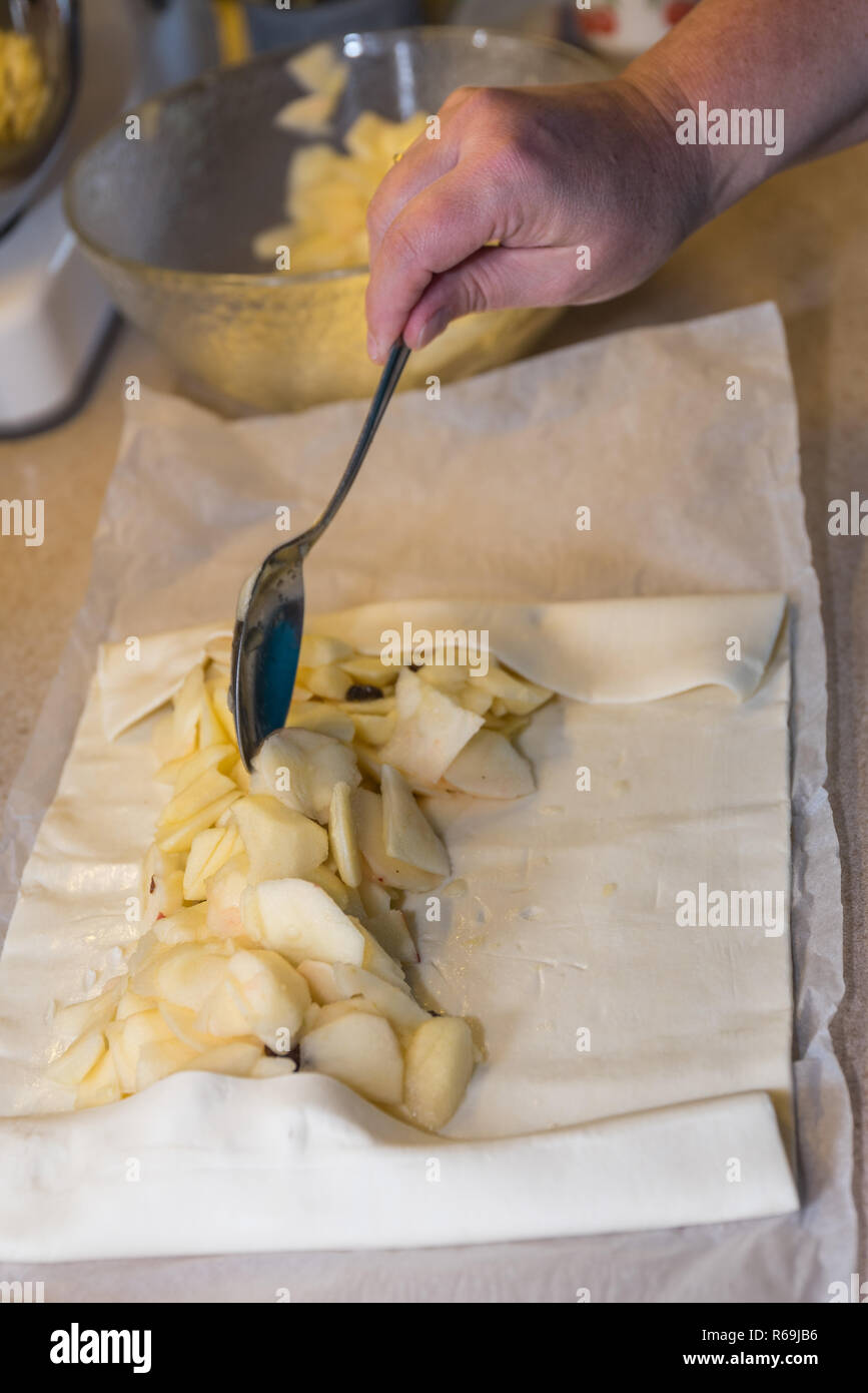 Mettere il ripieno in una fetta di torta di mele Foto Stock