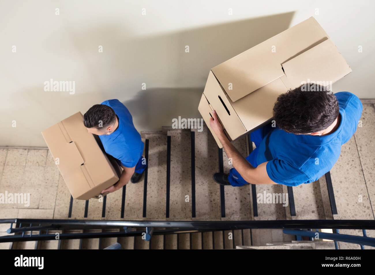 Due Movers trasportare le scatole di cartone sulla scala Foto stock - Alamy