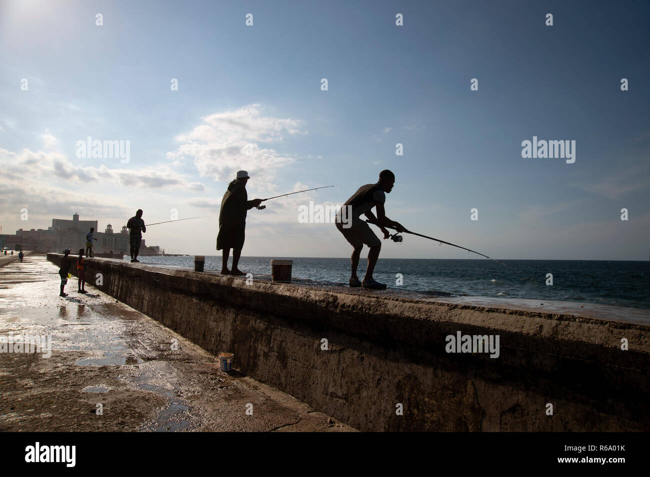 Sagome di uomini cubani la pesca al largo il Malecon in Havana Cuba Foto Stock