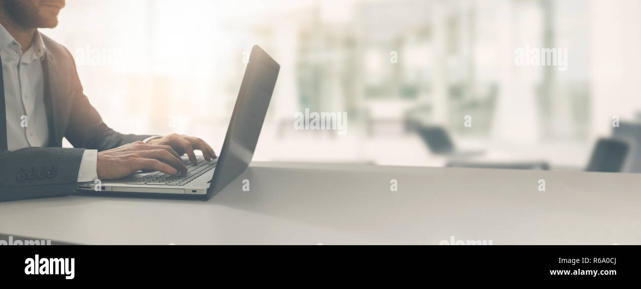 Giovane imprenditore lavorando sul computer portatile in moderno luminoso ufficio coworking. spazio copia Foto Stock