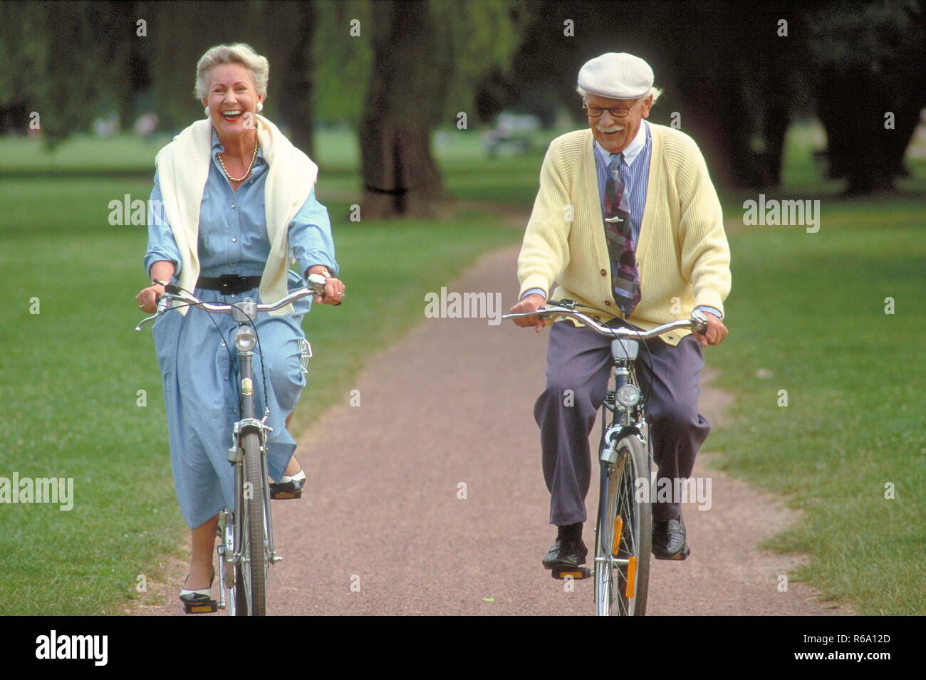 Ritratto, Parkszene, Seniorenpaar, unterwegs mit den Fahrraedern auf einem Parkweg Foto Stock