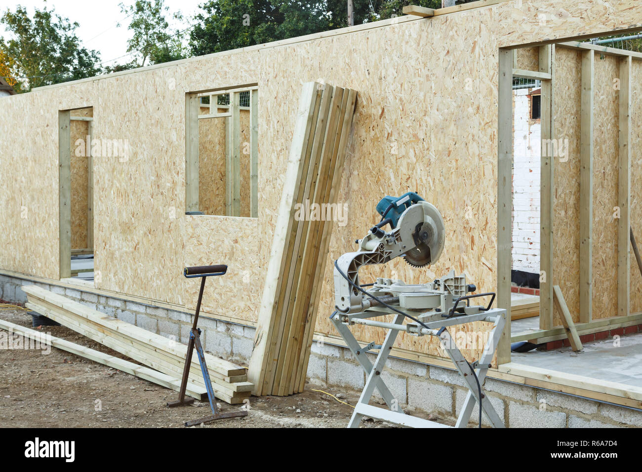 Una casa con struttura in legno è costruito utilizzando OSB i fogli per formare pannelli di legno. Carpenter's chop vide in primo piano Foto Stock