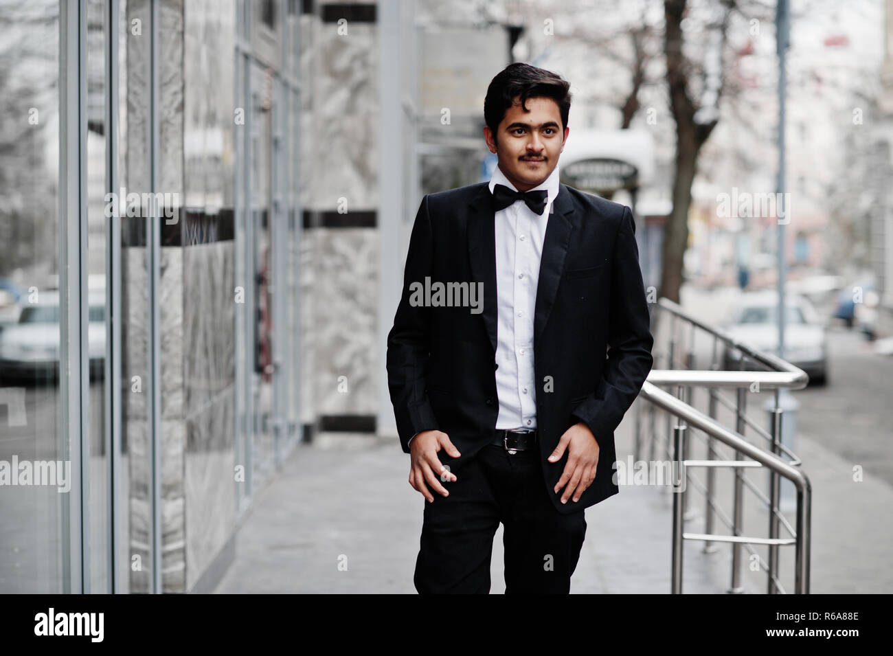 Giovani indiani uomo in abito nero e il filtro bow tie poste all'esterno  Foto stock - Alamy