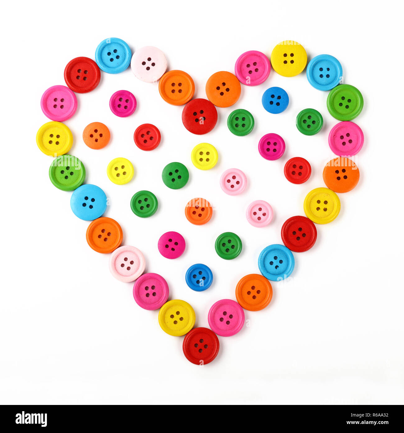 A forma di cuore di colorati pulsanti di cucitura su bianco Foto Stock