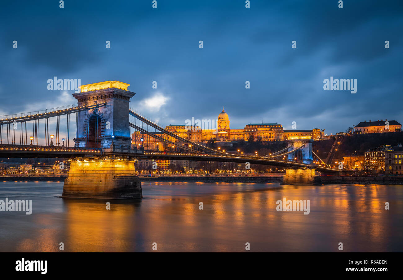 Budapest, Ungheria - bellissimo Ponte delle catene di Szechenyi in un unico colore blu con il Castello di Buda Royal Palace a sfondo al tramonto Foto Stock