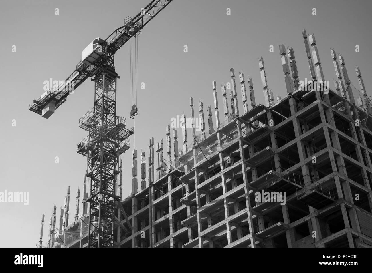Gru da cantiere nel processo di costruzione di un nuovo edificio residenziale. La costruzione di un edificio con appartamenti vista dal basso Foto Stock