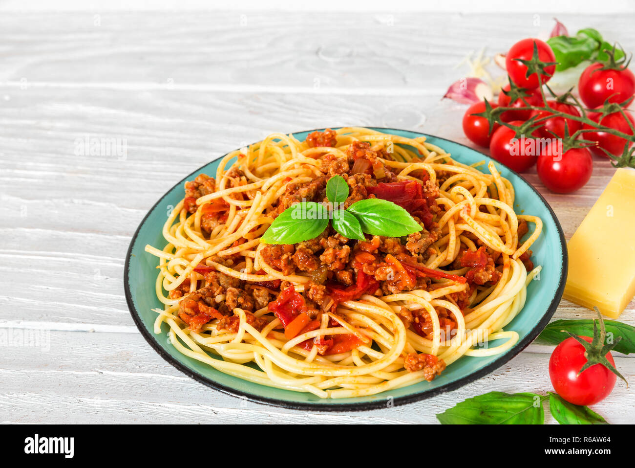 Pasta spaghetti alla bolognese su una piastra blu su bianco tavolo in legno. cibo sano. close up Foto Stock
