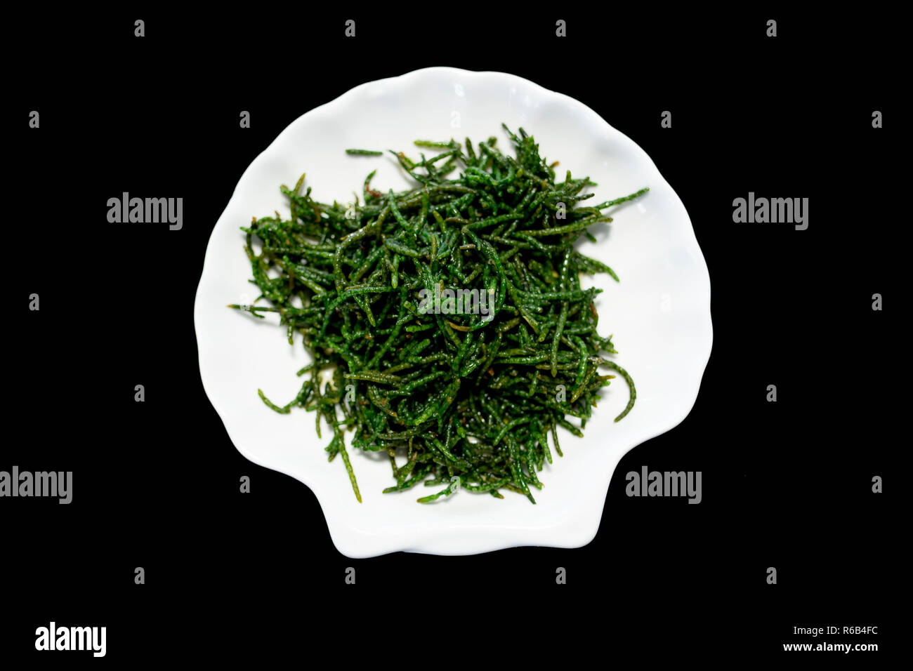 Fagioli mare salicornie pickleweed o insalata di Salicornia sulla piastra con sfondo nero Foto Stock