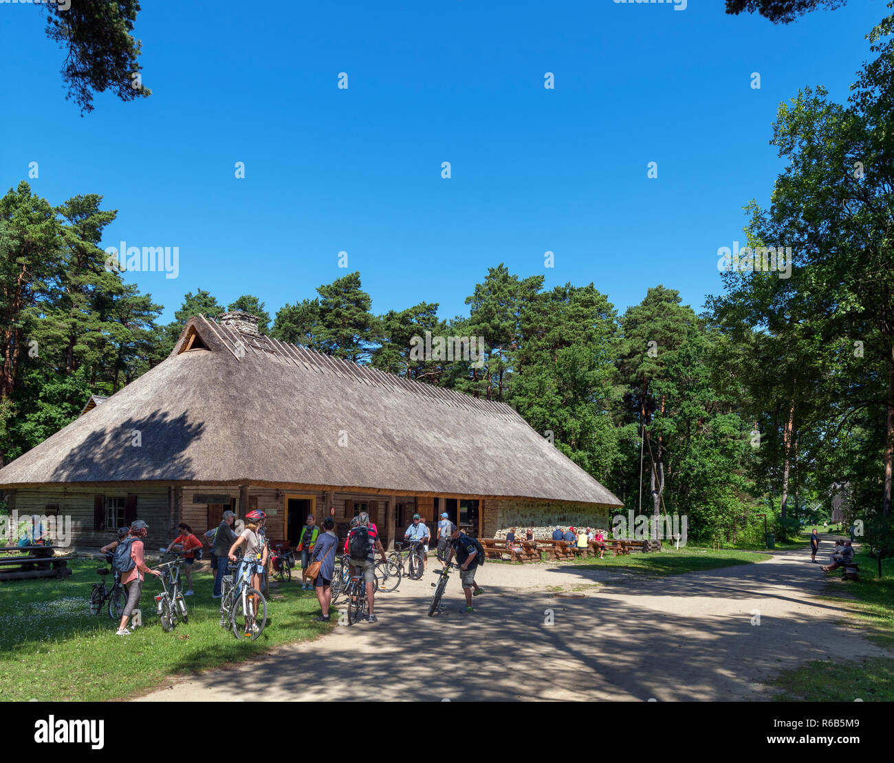 I ciclisti al di fuori del XIX secolo Kolu stradale Inn (dal villaggio Kolu in Harju County), Estonian Open Air Museum (Vabaõhumuuseum), Tallinn, Estonia Foto Stock